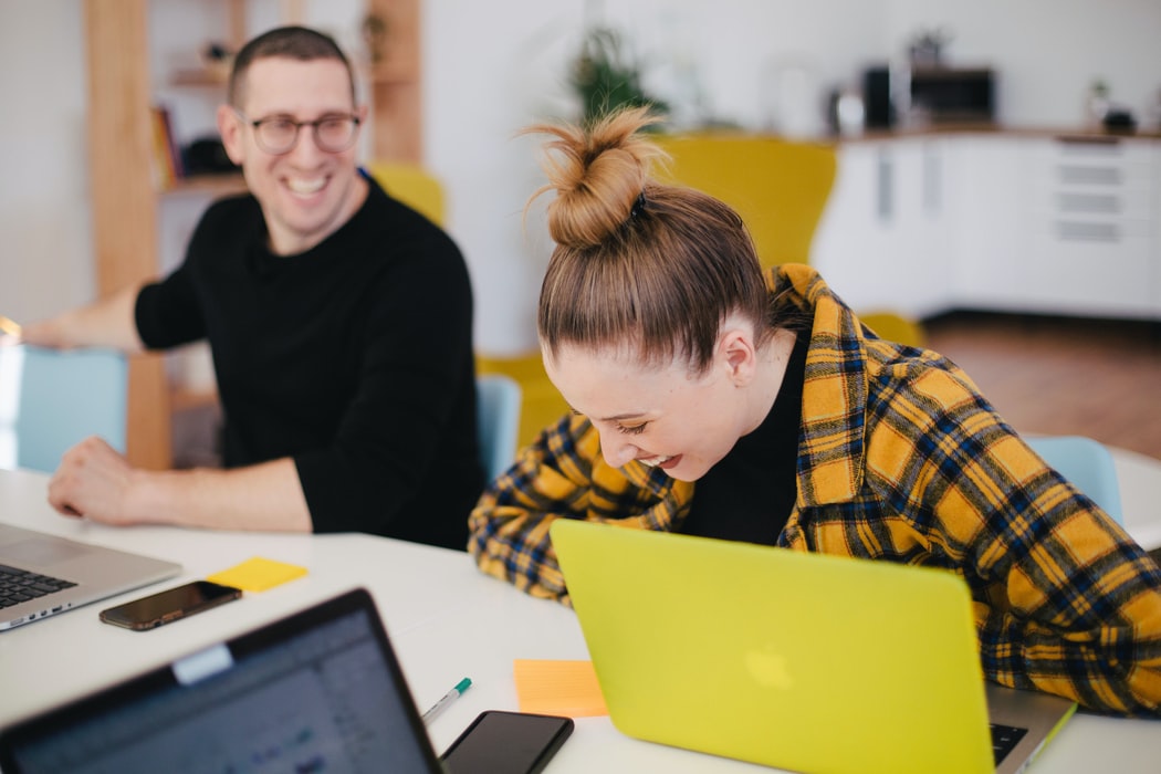 Two HR Coworkers Looking Happy And Laughing at Work